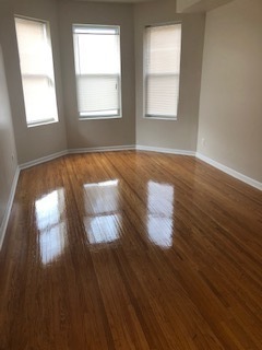6507 South Rhodes Avenue Chicago, IL 60637 - Photo 2 of 9 a view of an empty room with wooden floor and a window