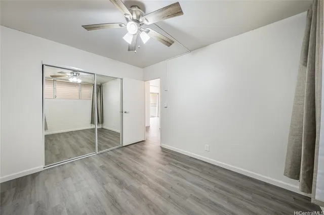a view of a livingroom with wooden floor and a ceiling fan
