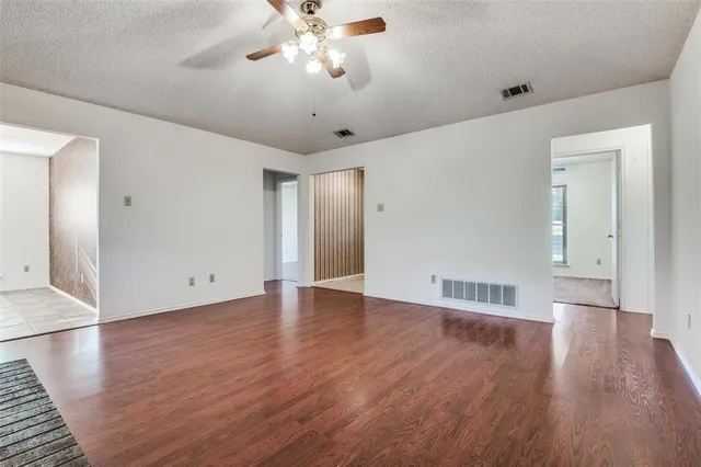 a view of an empty room with wooden floor