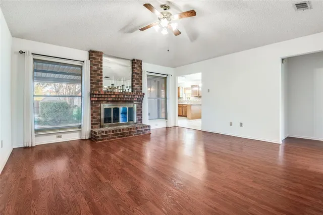 a view of an empty room with a fireplace and a window