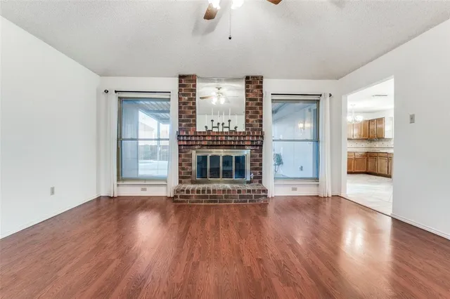a view of a livingroom with wooden floor a fireplace and window