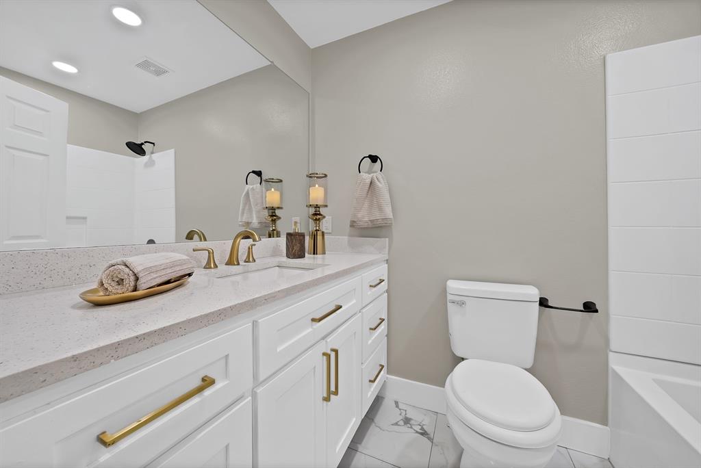 620 East 6th Street Springtown, TX 76082 - Photo 7 of 40 a bathroom with a toilet a sink and a mirror