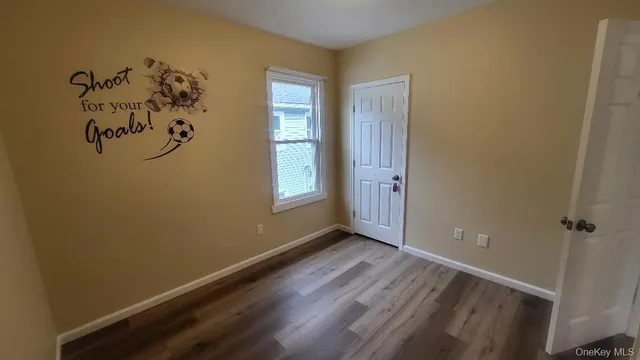 an empty room with windows and wooden floor