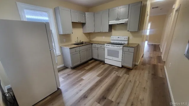 a kitchen with white cabinets and white appliances