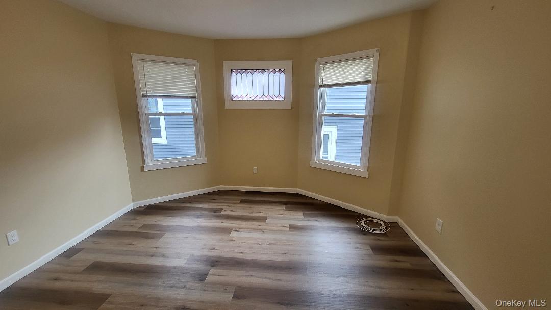 19 Hoffman Avenue, Unit 2 Poughkeepsie, NY 12603 - Photo 8 of 21 an empty room with wooden floor and windows