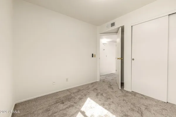 an empty room with closet and a bathroom