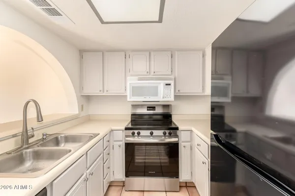 a kitchen with granite countertop a stove sink and cabinets