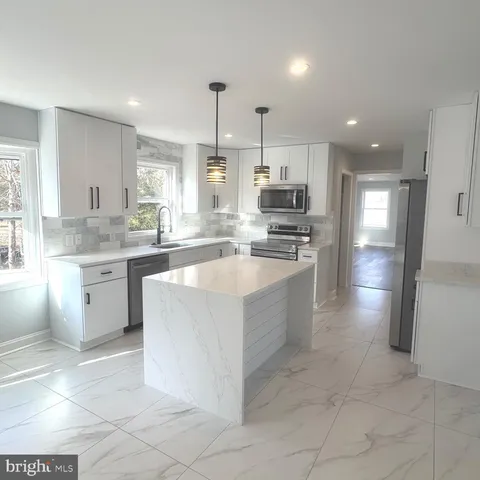 en empty room with windows and ceiling fan