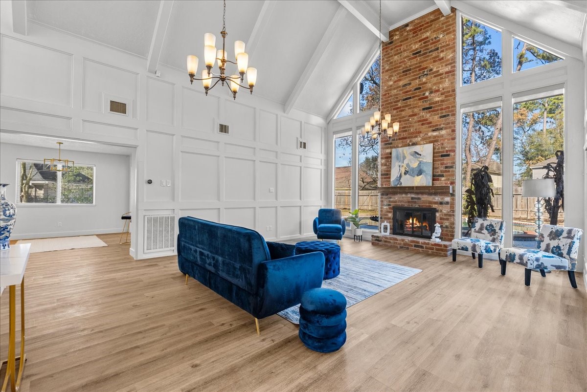 a living room with furniture a fireplace and a chandelier