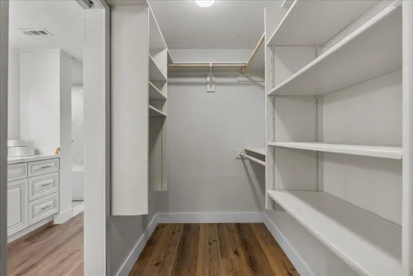 a view of a bedroom with wooden floor