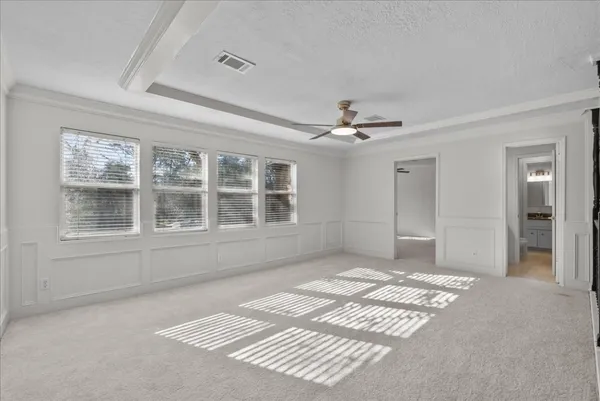 a view of a bedroom with a ceiling fan and a chandelier fan