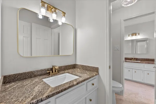 a bathroom with a granite countertop sink a mirror and shower
