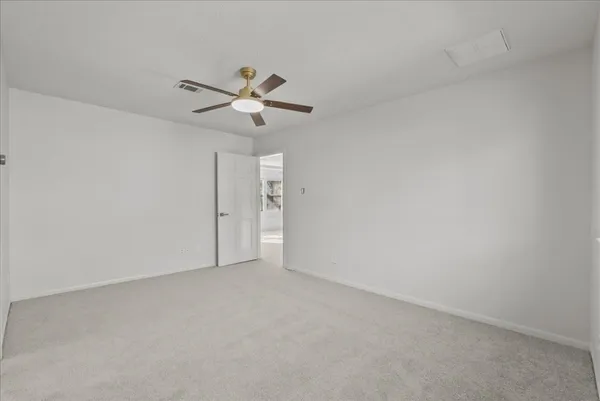 an empty room with a window and a ceiling fan