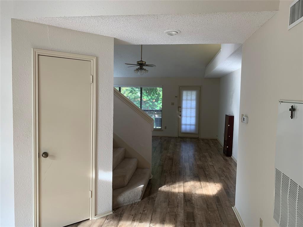 Hallway featuring wood finished floors, stairway, and a textured ceiling