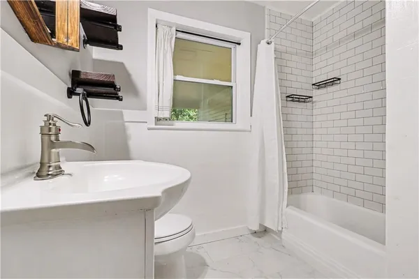 a bathroom with a sink a toilet and bathtub