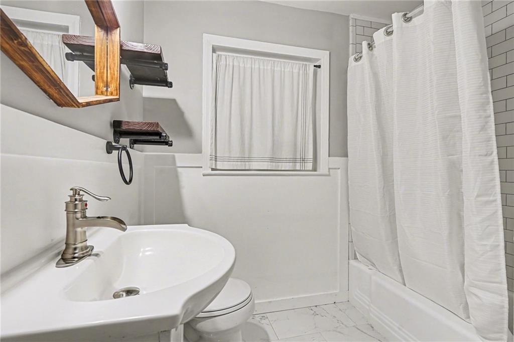 4139 Rebecca Street Southwest Covington, GA 30014 - Photo 26 of 33 a bathroom with a sink a mirror and a shower