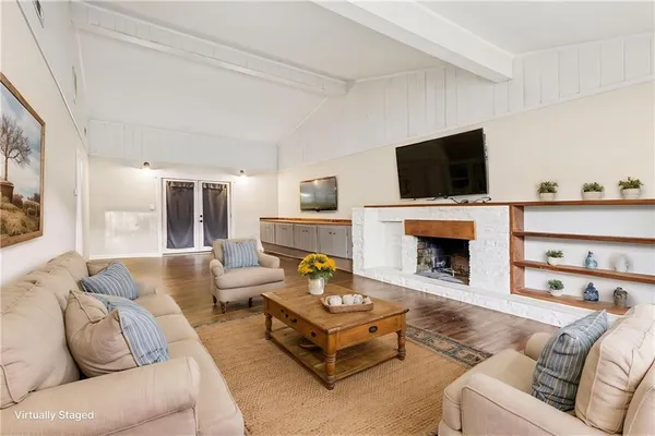 a living room with furniture a fireplace and a flat screen tv
