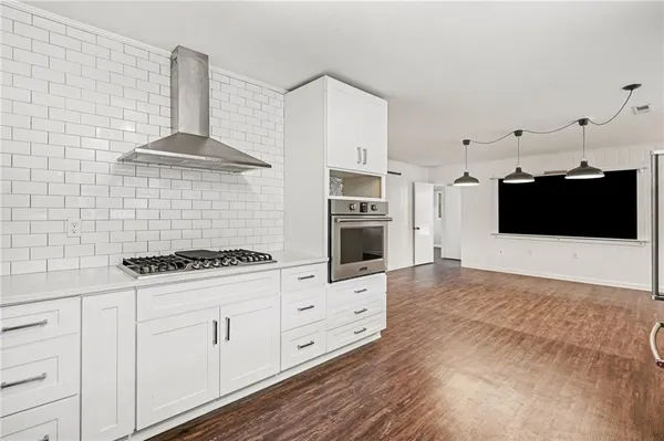 a kitchen with stainless steel appliances a white stove top oven and cabinets