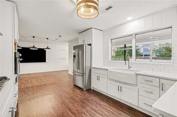 a kitchen with cabinets and wooden floor