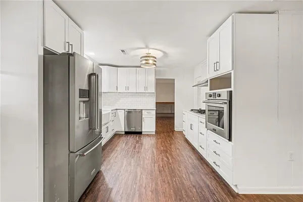 a kitchen with stainless steel appliances a refrigerator and a stove top oven
