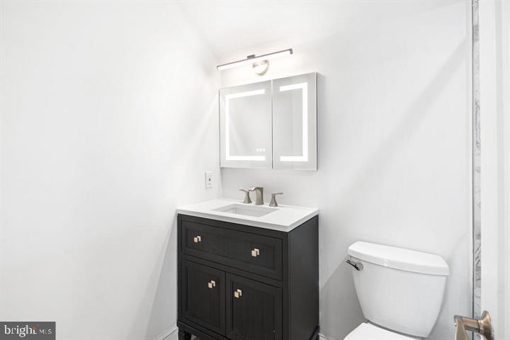 306 South 10th Street, Unit D Philadelphia, PA 19107 - Photo 18 of 35 a bathroom with a toilet a sink a mirror and vanity