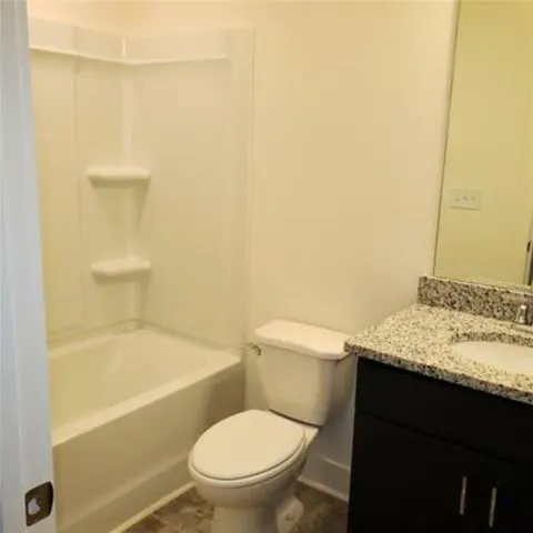 a white toilet sitting next to a bath tub