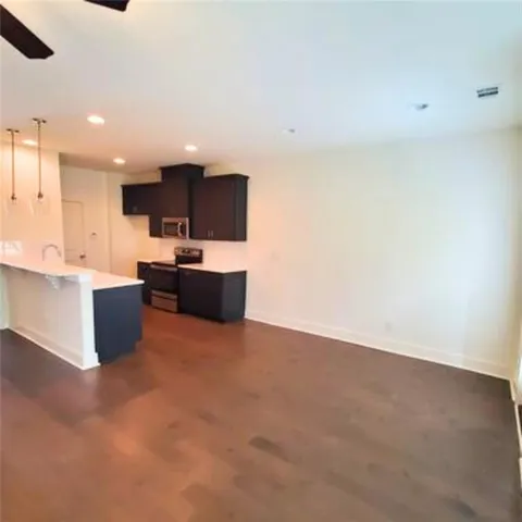 a kitchen with kitchen island a sink a stove and a microwave oven