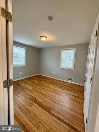 a view of empty room with window and wooden floor
