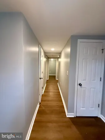 a view of a hallway with wooden floor and stairs