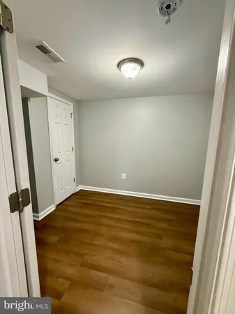 an empty room with wooden floor and window