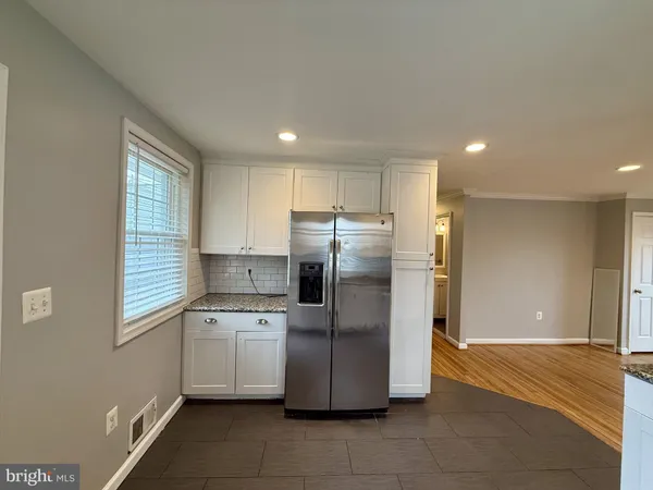 a kitchen with stainless steel appliances granite countertop a refrigerator and a stove