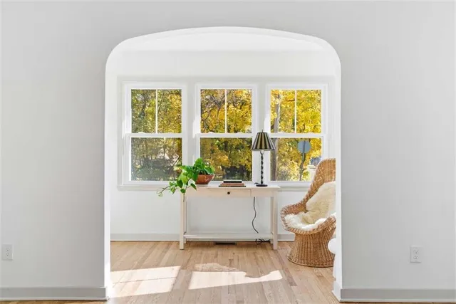 a living room with a large window and potted plants