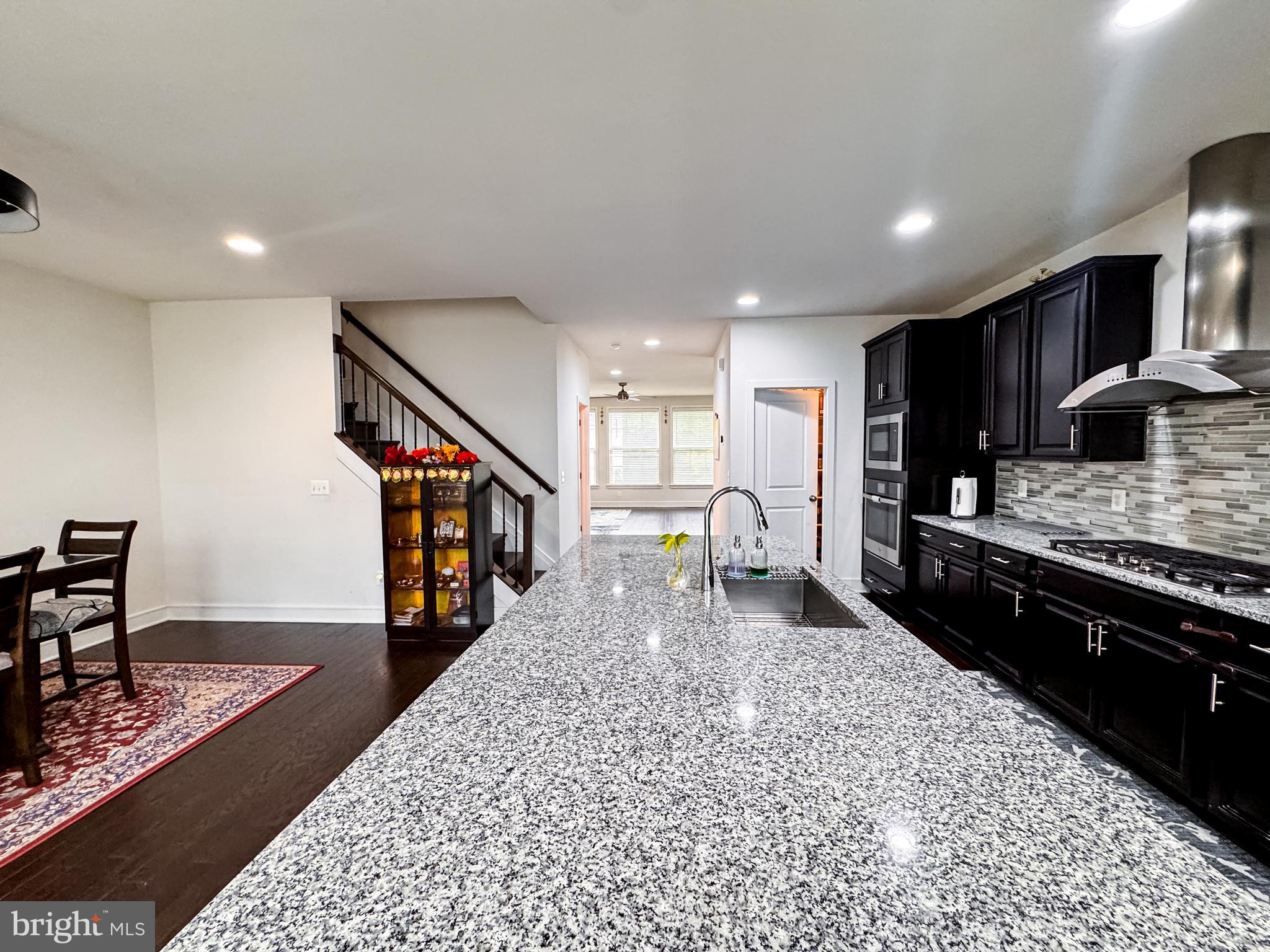 25419 Reed Orchard Terrace Chantilly, VA 20152 - Photo 22 of 47 a kitchen with stainless steel appliances kitchen island granite countertop a refrigerator a stove and a sink with granite countertops