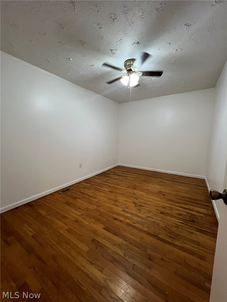 1105 Dutch Ridge Road Guysville, OH 45735 - Photo 9 of 33 Hardwood flooring spans this room, featuring white walls and a ceiling-mounted fan with integrated lighting
