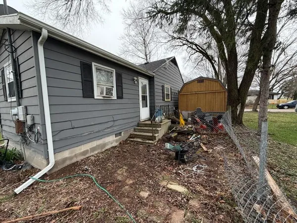 a backyard of a house with table and chairs