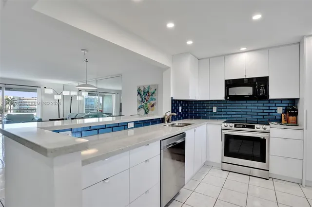 a kitchen with granite countertop stainless steel appliances a stove sink and cabinets