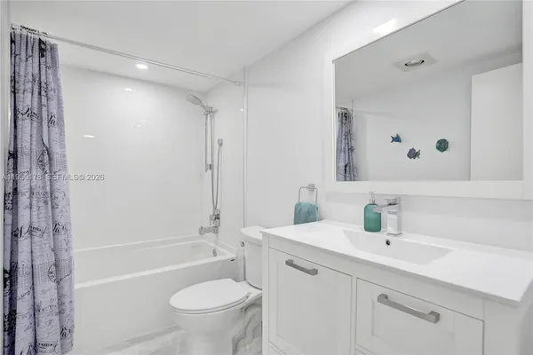 a bathroom with a sink a toilet and a large mirror