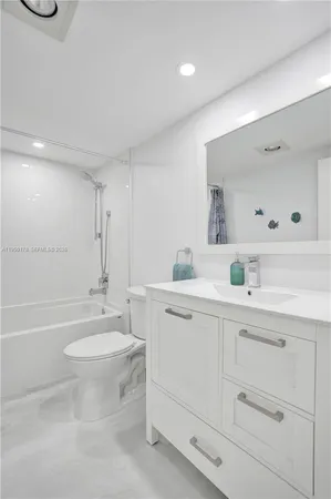 a bathroom with a toilet a sink a tub and mirror