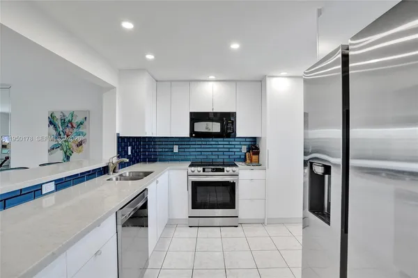 a kitchen with a refrigerator and a stove top oven