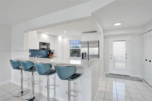 a kitchen with stainless steel appliances kitchen island granite countertop a refrigerator and a stove top oven