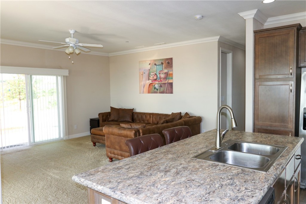 24000 Oak Cir Drive Wildomar, CA 92595 - Photo 9 of 22 a kitchen with kitchen island a sink granite counter top a window and living room