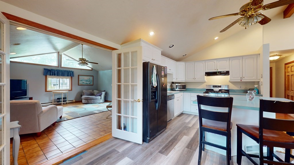 8 Fernwood Road Billerica, MA 01821 - Photo 8 of 23 a kitchen with stainless steel appliances granite countertop a refrigerator a stove a sink a dining table and chairs with wooden floor