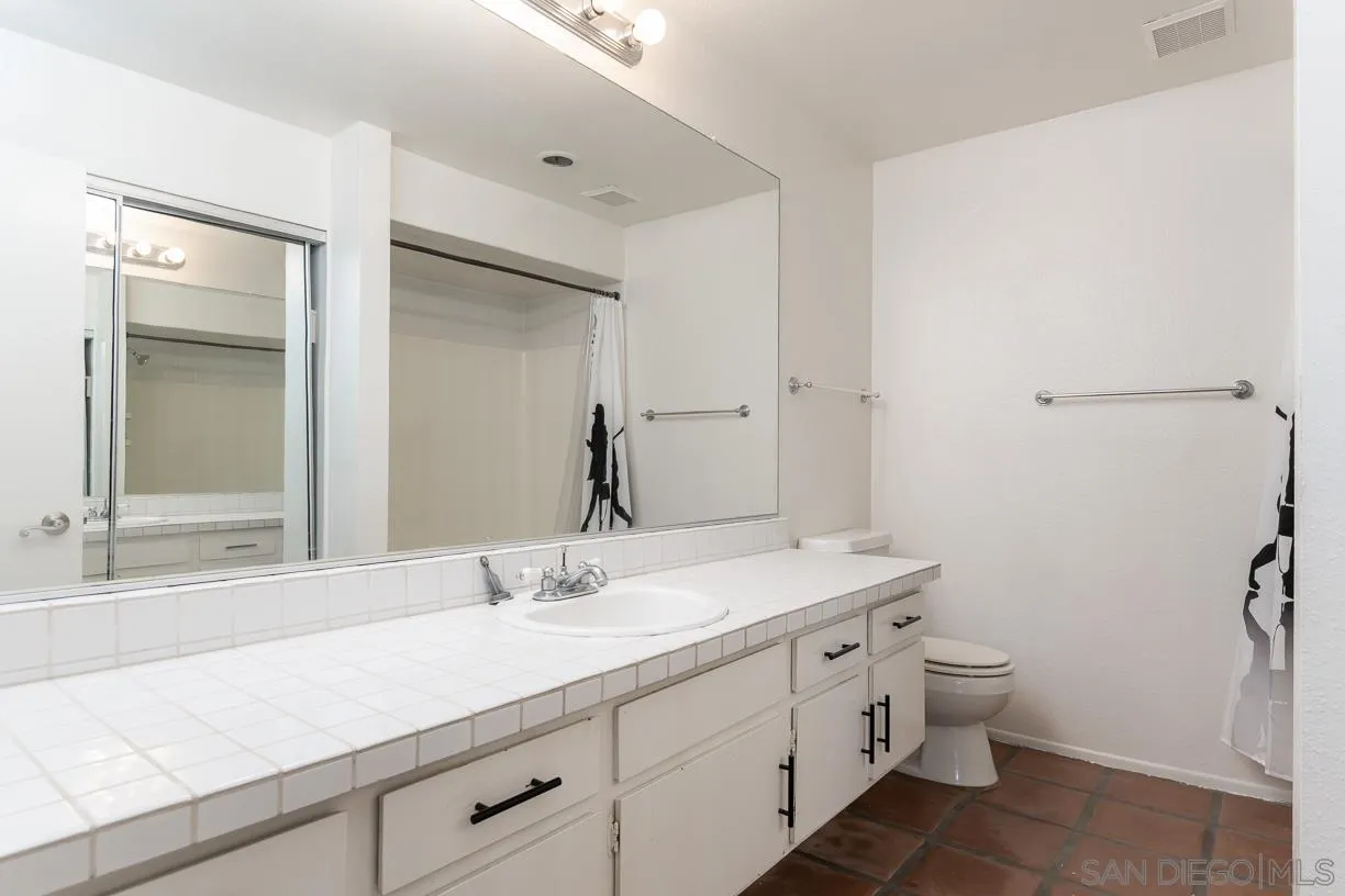 6314 Friars Road, Unit 301 San Diego, CA 92108 - Photo 16 of 31 a bathroom with a double vanity sink toilet and a mirror