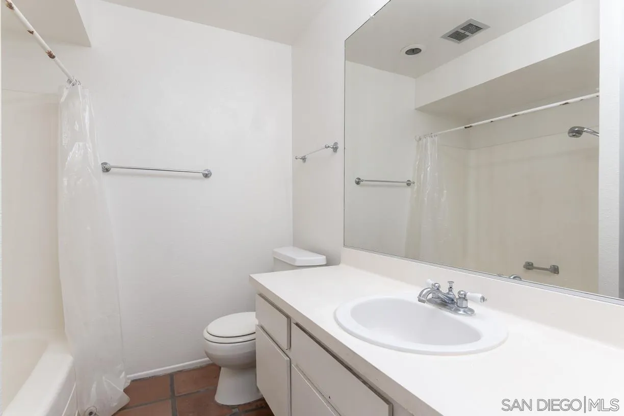6314 Friars Road, Unit 301 San Diego, CA 92108 - Photo 18 of 31 a bathroom with a toilet a sink a mirror and vanity