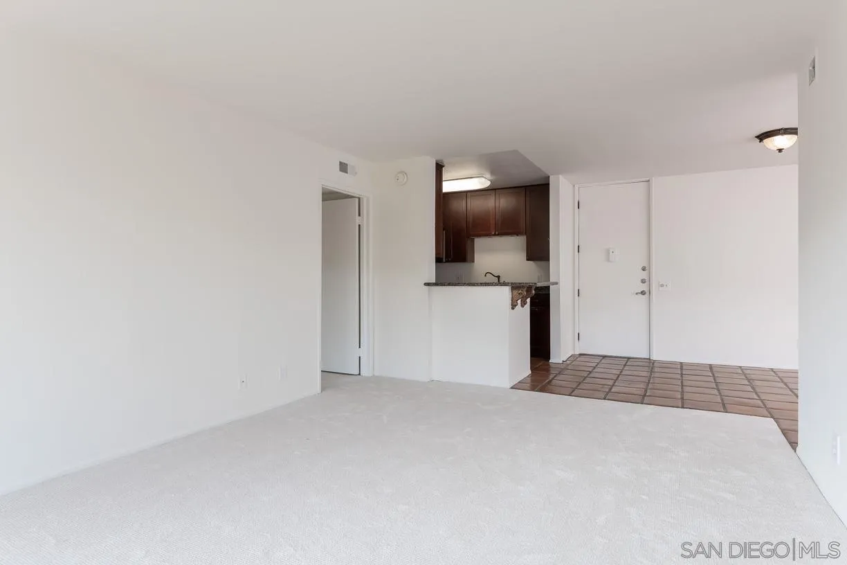 6314 Friars Road, Unit 301 San Diego, CA 92108 - Photo 5 of 31 a view of a livingroom with wooden floor and a refrigerator