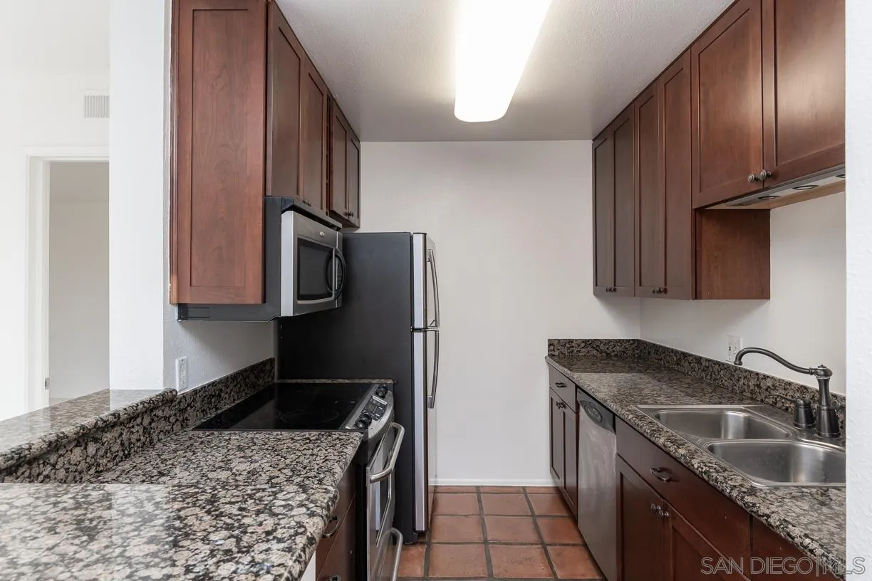 6314 Friars Road, Unit 301 San Diego, CA 92108 - Photo 7 of 31 a kitchen with stainless steel appliances granite countertop a sink stove and refrigerator