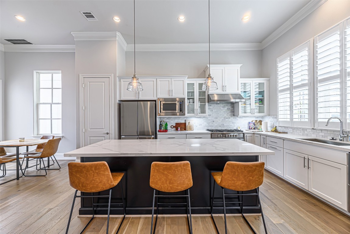 2414 Hollister Road Houston, TX 77080 - Photo 3 of 23 a kitchen with stainless steel appliances granite countertop a table chairs sink and wooden floor