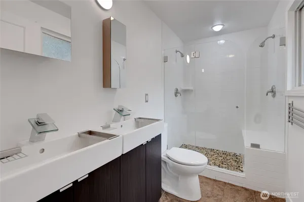a bathroom with a sink a toilet and shower