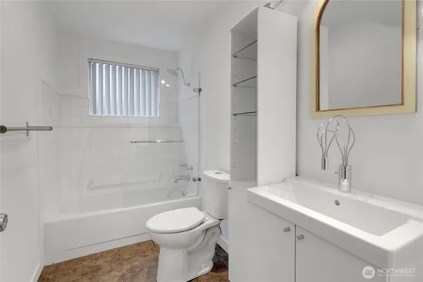 a bathroom with a toilet a sink a mirror and bathtub