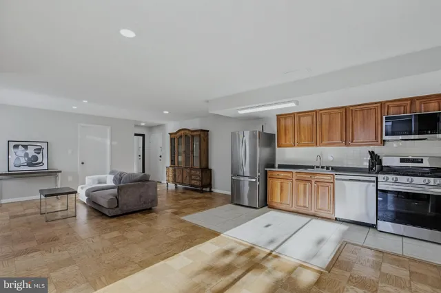 a kitchen with stainless steel appliances kitchen island granite countertop a refrigerator and stove top oven